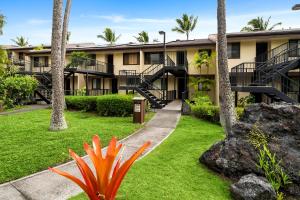 a building with palm trees and a plant at Country Club Villas 338 in Kailua-Kona