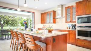a kitchen with a breakfast bar with wooden cabinets at Holua Kai 2 in Kailua-Kona