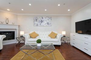 a living room with a white couch and a tv at Spacious 2BR/2.5BA + Game Room in Glendale