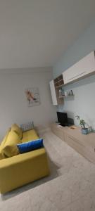 a living room with a yellow couch and a laptop at Best Residence Termoli in Termoli