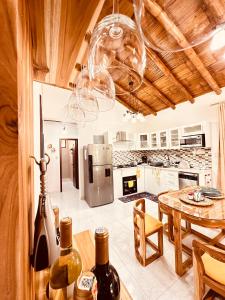 cocina con techo de madera y mesa con botellas de vino en Cabaña de Elsa, en Olón