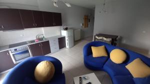 a living room with a blue couch and a kitchen at Gerard Luxury apartment in Patra