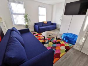 a living room with a blue couch and a table at The Bob Marley 'One Love' Apartment, Relaxed Vibes in Liverpool