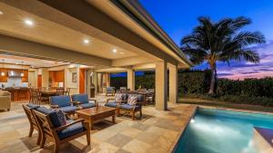 a patio with a pool and chairs and a house at Wai'ula'ula 334 at Mauna Kea in Hapuna Beach