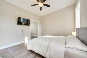 - une chambre blanche avec un lit et un ventilateur de plafond dans l'établissement Spacious Troy Apartment - Walk to Downtown!, à Troy
