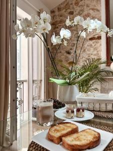 昂蒂布的住宿－L appartement de Manon, centre historique du vieil Antibes，一张桌子,上面放着两盘面包和白色的花