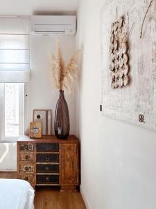 - une chambre avec un vase sur une commode en bois et une fenêtre dans l'établissement L appartement de Manon, centre historique du vieil Antibes, à Antibes