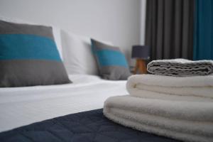 a stack of towels sitting on a bed at Modern City Center 2 Bedroom Apartment in Sofia