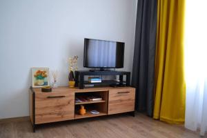 a tv sitting on top of a wooden entertainment center at Modern City Center 2 Bedroom Apartment in Sofia