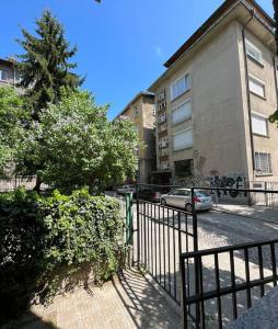 a car parked in front of a building with a fence at Modern City Center 2 Bedroom Apartment in Sofia