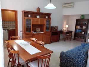 cocina con mesa de madera y sillas en CASA FIGUS Via Roma 20 Narbolia, en Narbolia