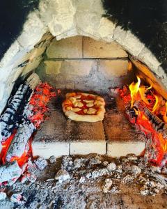 a pizza is cooking in a brick oven at Walnut Cottage 1 in Deredzhik-Kʼoy