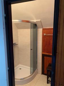 a shower with a glass door in a bathroom at Chata na lúke in Tatranska Strba