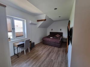 niewielka sypialnia z łóżkiem, biurkiem i stołem w obiekcie Black Horse Apartament’s w mieście Chojnice