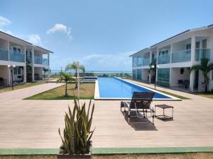 a swimming pool in front of a building at Bangalô duplex 602 - Riviera do Atlântico in Conde