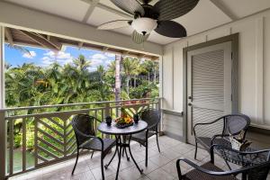 a balcony with a table and chairs and a ceiling fan at Palm Villas at Mauna Lani I23 in Waikoloa