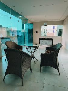 uma sala de jantar com cadeiras, uma mesa e uma mesa de vidro em Bangalô duplex 602 - Riviera do Atlântico em Conde