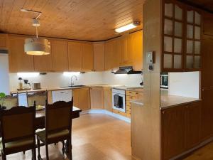 a kitchen with wooden cabinets and a table with chairs at Villa Sahi in Iisalmi