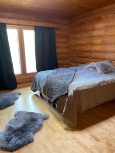 a bedroom with a bed in a log cabin at Villa Sahi in Iisalmi