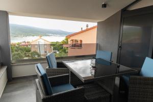 a balcony with a table and chairs and a view at Apartments Pina in Kornić