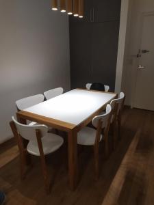 una mesa de comedor con sillas blancas alrededor en Palermo Apart Bulnes, en Buenos Aires 2 fotos más