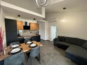 a kitchen and living room with a table and a couch at Apartments Pina in Kornić