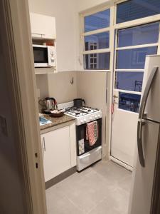 Una pequeña cocina con estufa y ventana. en Palermo Apart Bulnes, en Buenos Aires
