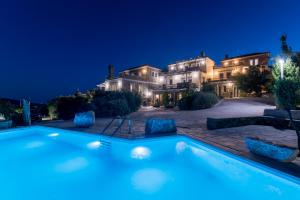 a large house with a swimming pool at night at Petrina Volia - Residence Anemos in Andros