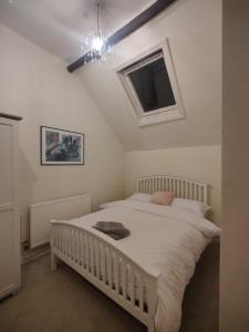 ein Schlafzimmer mit einem weißen Bett und einem TV in der Unterkunft The Dairy in Pershore