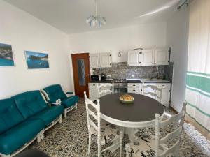 a kitchen with a table and a blue couch at Montes in Dorgali