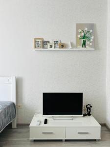 uma sala de estar com uma televisão num armário branco em Апартаменты «Одесские традиции» em Odessa