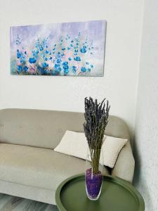 a vase on a table in front of a couch at Апартаменты «Одесские традиции» in Odesa