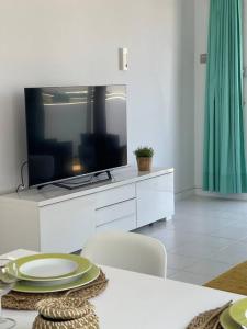 a living room with a television on a white dresser at CASA MESANA Nuevo cama King size en playa con AIRE ACONDICIONADO in Playa Honda