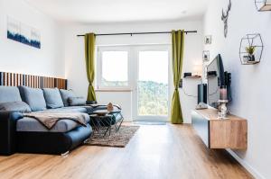 een woonkamer met een bank en een tv bij Neu stilvoll komplett Ausgestattet Fewo Gratis Wein und Getränke bei Ankunft in Saldenburg