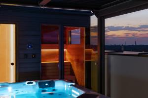 a jacuzzi tub on a balcony with a sunset at Best Apartment SPA in Rzeszów