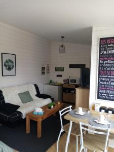 un salon avec un canapé et une table dans l'établissement Sucrée et Douceur, à Cabourg