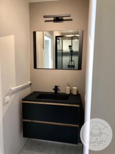 a bathroom with a black sink and a mirror at Appartement Sealight in De Haan