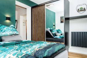 een slaapkamer met een blauw bed en een spiegel bij Neu stilvoll komplett Ausgestattet Fewo Gratis Wein und Getränke bei Ankunft in Saldenburg