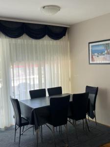 uma sala de jantar com uma mesa preta e cadeiras em Apartment Adriana em Biograd na Moru