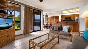 a living room with a couch and a tv at The Shores at Waikoloa 117 in Waikoloa