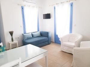 a living room with a blue couch and a chair at Kostantis Vacation Home 1 in Ambelas