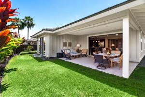 a yard with a patio and grass at Holua Kai 37 in Kailua-Kona