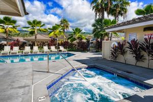 a swimming pool with chairs and a swimming pool at Holua Kai 37 in Kailua-Kona