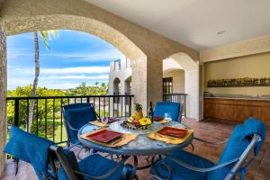 a dining room with a table and chairs on a balcony at The Shores at Waikoloa 202 in Waikoloa