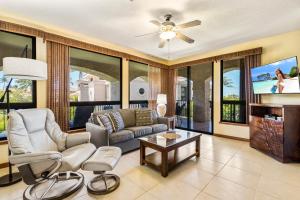a living room with a couch and a tv at The Shores at Waikoloa 202 in Waikoloa