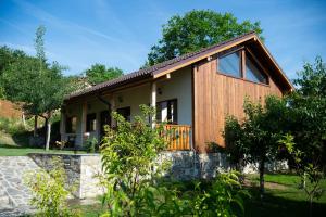 a home with a wooden facade with a stone wall at Walnut Cottage 1 in Deredzhik-Kʼoy