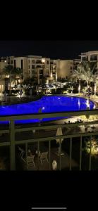 - une piscine avec éclairage bleu dans une ville la nuit dans l'établissement marassi chalet, à El Alamein