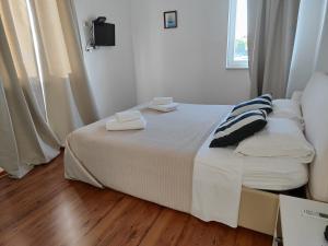 a bedroom with a bed with two towels on it at Guest House Adria in Primošten