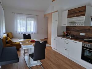 een keuken en een woonkamer met een tafel en stoelen bij Appartement Lindenheim in Sankt Kanzian