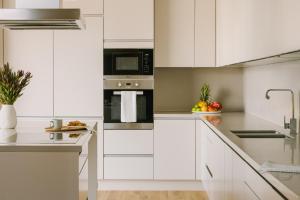 - une cuisine blanche avec des armoires et des appareils blancs dans l'établissement Sonder at JBR The Walk, à Dubaï